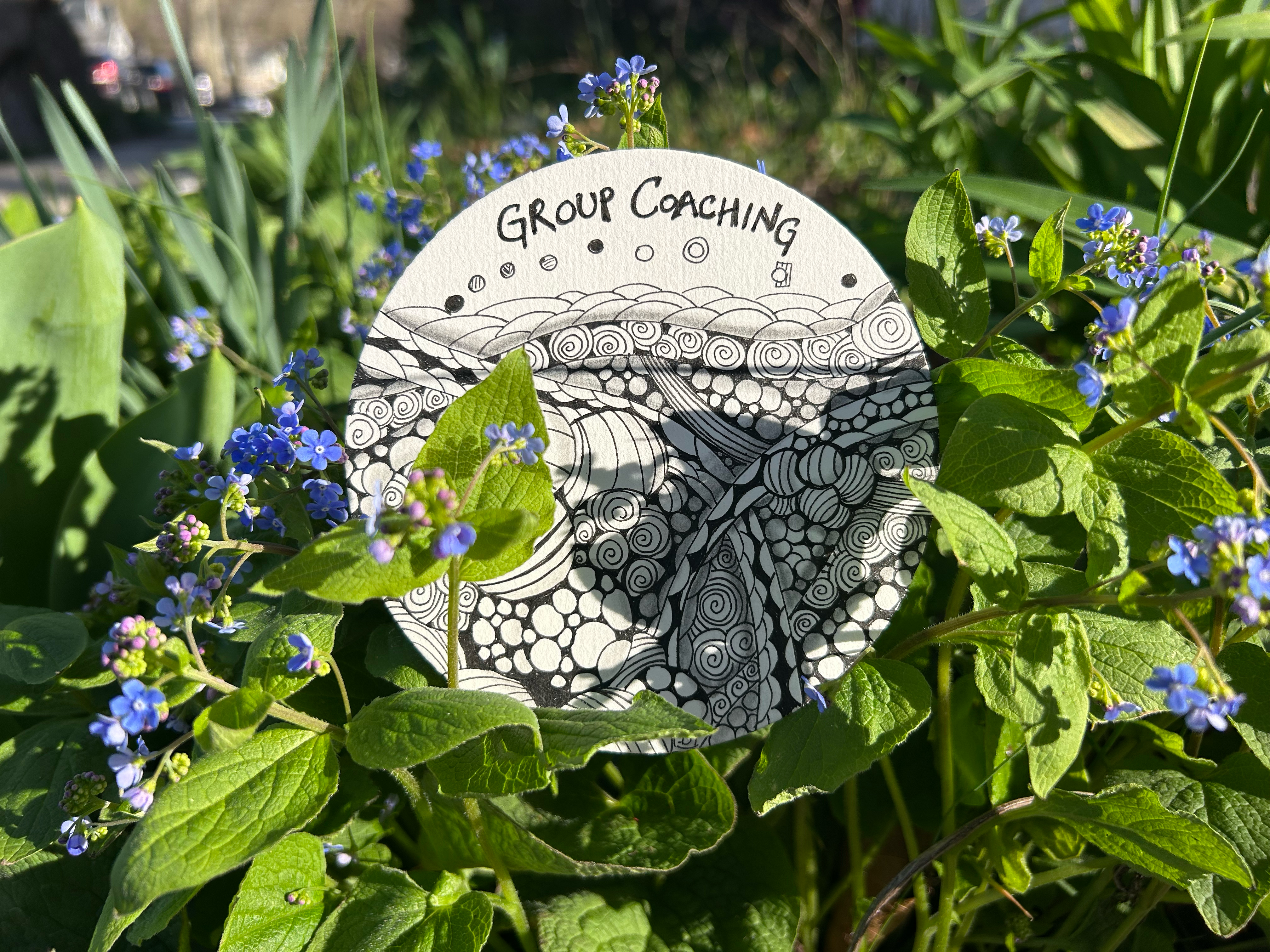 zentangle design placed in a bed of blue flowers