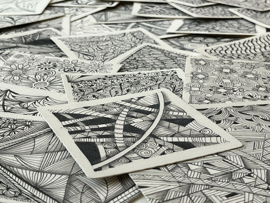 close up picture of a scattered group of zentangle artworks on a flat surface